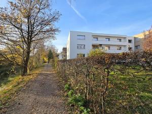 a dirt road in front of a white building at Urban Comfort, Zurich Airport - By River Glatt in Glattbrugg