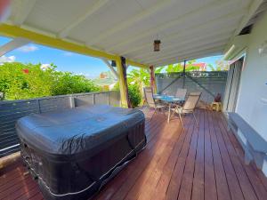 a large suitcase sitting on the deck of a house at Kanel' Kaz - Jacuzzi & Vue mer in Capesterre-Belle-Eau