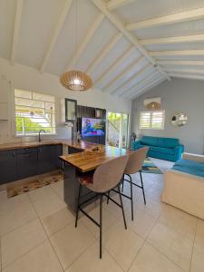 a kitchen and living room with a table and chairs at Kanel' Kaz - Jacuzzi & Vue mer in Capesterre-Belle-Eau