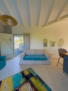 a living room with a couch and a table at Kanel' Kaz - Jacuzzi & Vue mer in Capesterre-Belle-Eau
