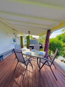 a patio with a table and chairs on a deck at Kanel' Kaz - Jacuzzi & Vue mer in Capesterre-Belle-Eau