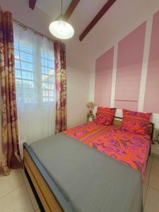a bedroom with a bed with red pillows at Kanel' Kaz - Jacuzzi & Vue mer in Capesterre-Belle-Eau +27 photos