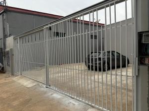 a fence with a car parked behind a building at Apto Completo - 100m da Av Weyne Cavalcante, Centr in Canaã dos Carajás
