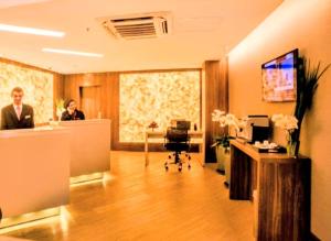 eine Lobby mit zwei Personen in einem Büro in der Unterkunft Hotel Signature Clarion BLUE - Luxury Veranda Edition - by PluXstay in São Paulo + 101 Fotos