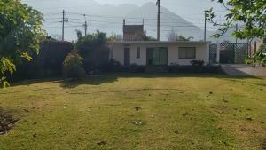 a yard with a house with a hose at La Casita de Condoray - Lunahuana in Lunahuaná