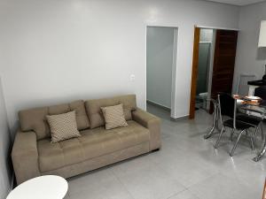 a living room with a couch and a table at Apto Completo - 100m da Av Weyne Cavalcante, Centr in Canaã dos Carajás +7 photos