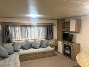 a living room with a couch in front of a window at Marton Mere 8 Berth Caravan in Blackpool