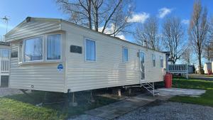 a white tiny house parked in a yard at Marton Mere 8 Berth Caravan in Blackpool