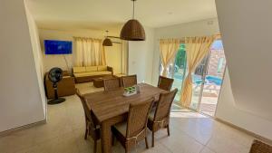 a dining room with a table and chairs and a couch at Cabaña Sisiguaca in Santa Marta
