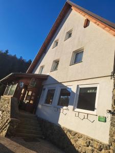 a house with a staircase leading to the front door at Gostišče Jelka, Hočko Pohorje in Pohorje