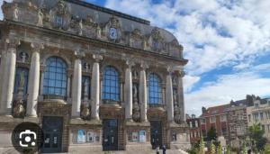 a large building with a clock on top of it at Le plein centre rez de chaussee au cœur de Calais in Calais