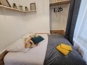 a bed with two pillows on it in a room at Le plein centre rez de chaussee au cœur de Calais in Calais