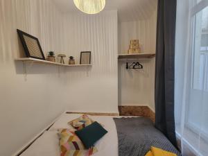 a small bedroom with a bed and a window at Le plein centre rez de chaussee au cœur de Calais in Calais