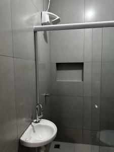 a white bathroom with a sink and a shower at Apto Completo - 100m da Av Weyne Cavalcante, Centr in Canaã dos Carajás