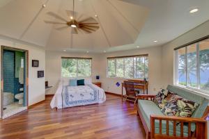 a bedroom with a bed and a couch and windows at Balinese Beach House With Pool in Pahoa