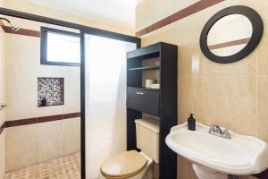 巴卡拉尔Casa Sirena - A orilla de la laguna y Cenote Esmeralda的浴室里有洗手池、马桶和镜子。 更多8张照片