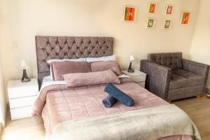 ein Schlafzimmer mit einem großen rosa Bett und einem Stuhl in der Unterkunft Corferias Embajada Usa Centro Aeropuerto Mascotas Coliving Coworking in Bogotá + 67 Fotos