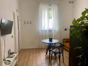 a living room with a table and chairs and a tv at AMA HOMe, appartamento in centro con terrazza in Ancona +50 photos