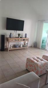 ein Wohnzimmer mit einem Flachbildfernseher an der Wand in der Unterkunft Oasis by the beach Retiro 1 in Punta Cana