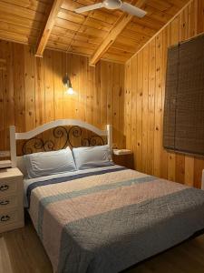 ein Schlafzimmer mit einem Bett mit Holzwänden und einer Decke in der Unterkunft Casa Rural Los Peralejos Piscina Privada en Cazorla in Cazorla