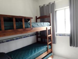 two bunk beds in a room with a window at Pink house Enseada Beach in Guarujá