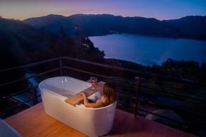 a woman sitting in a bath tub on a balcony at Pacucha Glamping in Andahuaylas