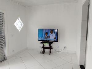 a flat screen tv on a white wall in a room at Pink house Enseada Beach in Guarujá
