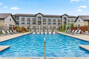a swimming pool with lounge chairs in front of a building at Modern A plus Location WorkerFriendly Pool Gym KINGbed in Sherman