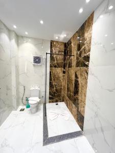 a bathroom with a toilet and a glass shower at Glamour Pyramids BoutiQue Hotel in Cairo +38 photos