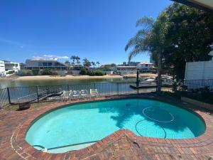 a swimming pool with chairs and a body of water at Exclusive Master Bedroom Room with Broadwater views in Gold Coast