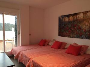 duas camas em um quarto com lençóis vermelhos em Casa Rural Nacimiento del Hueznar - Tomillo 17 em San Nicolás del Puerto