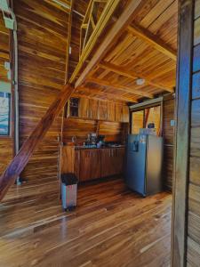 uma cozinha num chalé de madeira com um frigorífico em Refugio la Arboleda em São Rafael