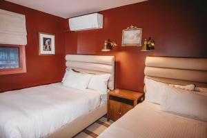 two beds in a room with red walls at Hideaway Inn Mt Snow in Dover +73 photos