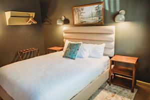a bedroom with a large white bed with a night stand at Hideaway Inn Mt Snow in Dover