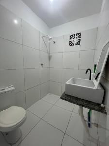 a white bathroom with a sink and a toilet at Apartamento da Kenia in Canoa Quebrada +34 photos
