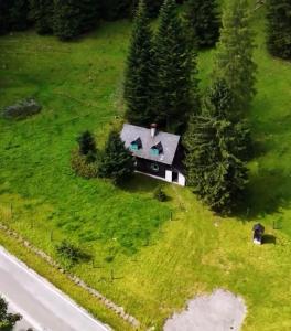 a model of a house on a green field with trees at Almhütte am Steirischen Seeberg in Turnau