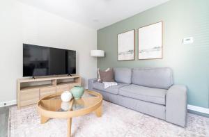 a living room with a couch and a tv at The Vibe on Durham V 8782 in Durham