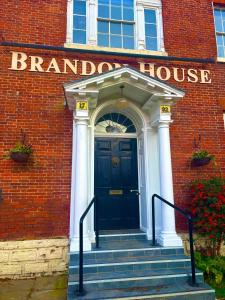 Una puerta de entrada de un edificio de ladrillo con una puerta azul. en Brandon House, en Brandon