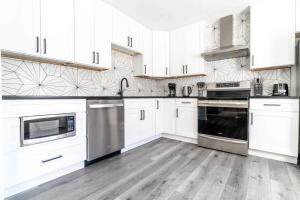a kitchen with white cabinets and stainless steel appliances at The Vibe on Durham VI 8783 in Durham +11 photos