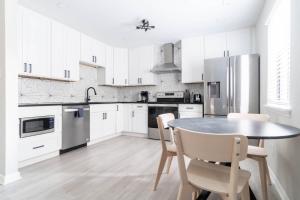 a kitchen with white cabinets and a table and chairs at The Vibe on Durham VI 8783 in Durham