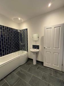Un baño con bañera, lavabo e inodoro. en Brandon House, en Brandon