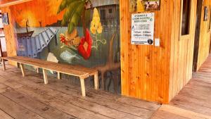 a wooden bench in front of a wall with a mural at Asoagropa in Buenaventura +1 photo