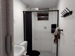 a bathroom with a shower and a toilet and a sink at Pink house Enseada Beach in Guarujá +37 photos