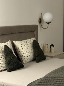 ein Bett mit zwei Kissen und einer Lampe darauf in der Unterkunft Belvedere Studio Apartman in Vukovar