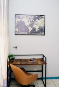 a desk with a chair and a map on the wall at The Treat Manzini in Manzini