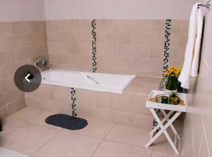 a bathroom with a tub and a sink at The Treat Manzini in Manzini +20 photos