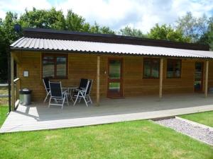 a house with chairs and a table in front of it at Woodside Cottages - Beech cottage - Self-catering in Fletching