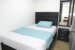 um pequeno quarto com uma cama com uma almofada azul em El ensueño em Manizales