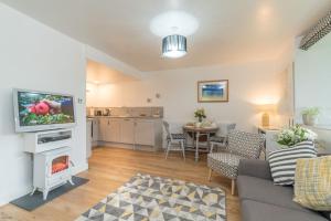 a living room with a couch and a tv and a table at Melin-Dwyfor in Criccieth