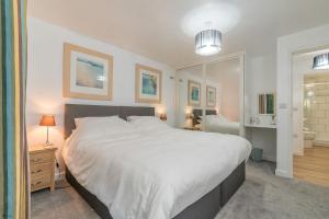 a bedroom with a large white bed and a mirror at Melin-Dwyfor in Criccieth +14 photos